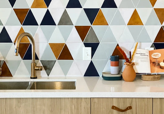 <a href="https://mercurymosaics.com/blogs/custom-gallery?modal-gallery=the-foxwell-triangle-backsplash">Large Triangles</a><br><a href="https://mercurymosaics.com/pages/color-palette#130-White">130 White</a>, <a href="https://mercurymosaics.com/pages/color-palette#77E-Grey">77E Grey</a>, <a href="https://mercurymosaics.com/pages/color-palette#60-Silver-Lining">60 Silver Lining</a>, <a href="https://mercurymosaics.com/pages/color-palette#65W-Amber">65W Amber</a>, <a href="https://mercurymosaics.com/pages/color-palette#61-Navy">61 Navy</a>, <a href="https://mercurymosaics.com/pages/color-palette#155-Steel">155 Steel</a>, <a href="https://mercurymosaics.com/pages/color-palette">Custom Color</a>